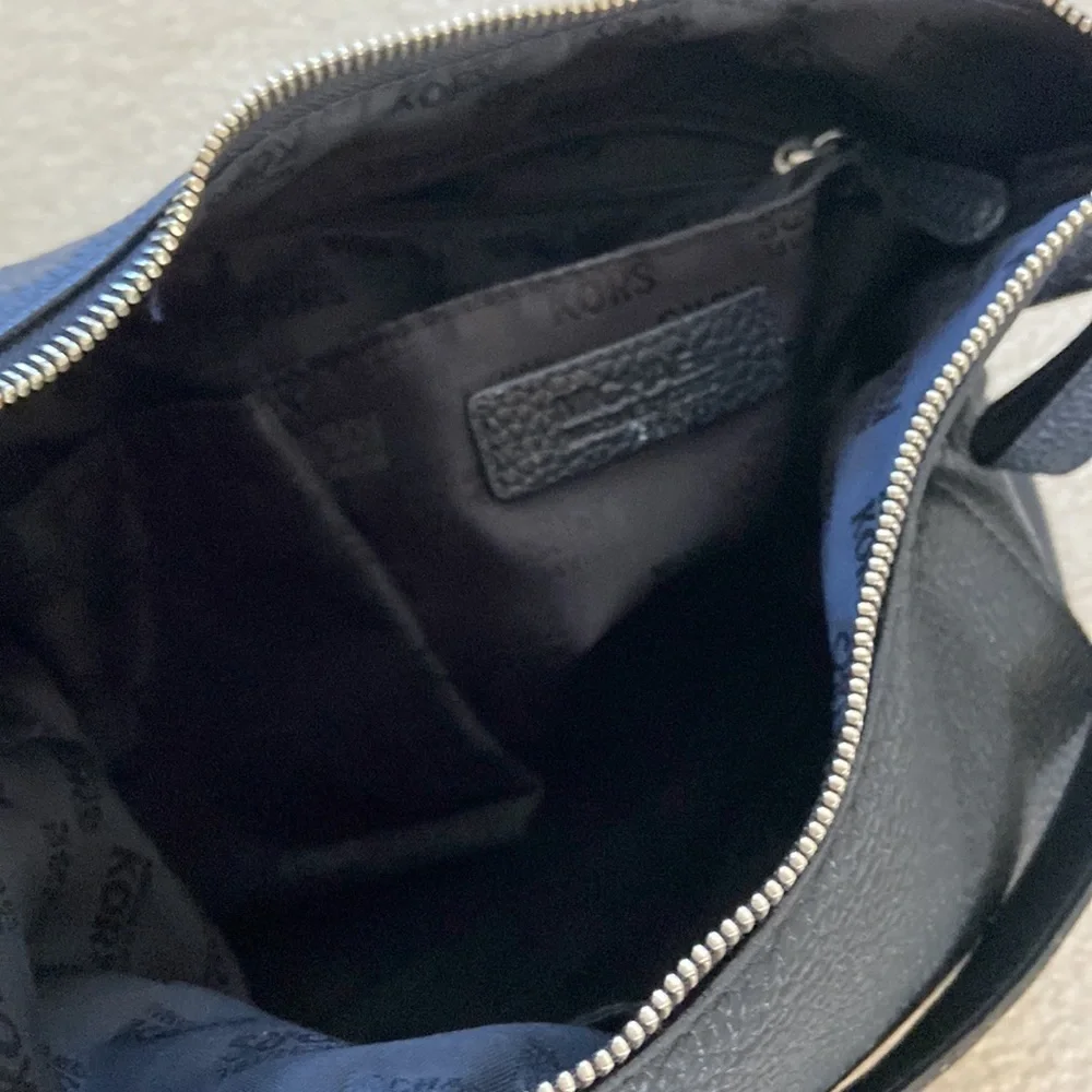 Michael Kors black leather shoulder bag, silver hardware logo on zipper, clean